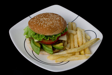 A delicious hamburger accompanied with french fries.
