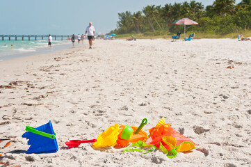 Fototapeta na wymiar top, front view, close distance of a group of colorful, plastic, beach toys on a sandy, tropical beach on the gulf of Mexico on a sunny morning