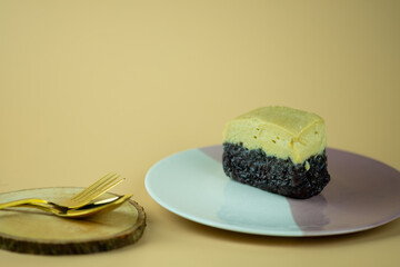 Sweet egg custard over sweet black sticky rice on plate.