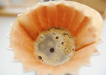Coffee blooming close up. Brewing in origami dripper