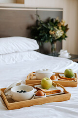 Breakfast in the hotel. Porridge, boiled egg, toast, coffee, porridge with berries on a tray. High quality photo