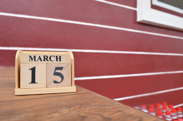 March 15, Number cube with wooden table beside the wall.