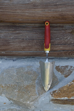 Garden scoop on the background of a fragment of the wall of a wooden house