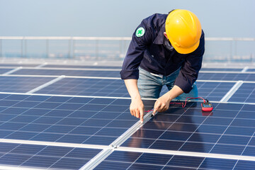 Electrician engineer with a helmet yellow is inspection the solar panel on the roof of the...