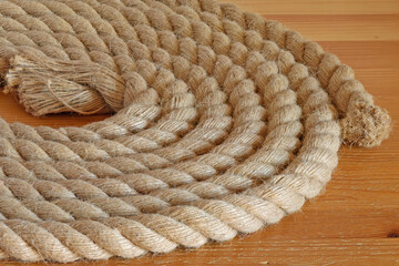 A fragment of a hemp rope on a wooden table top close up