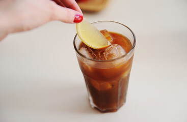 Making espresso tonic. Adding a lemon slice into espresso tonic