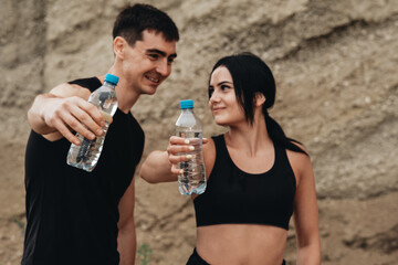 Two Athletes in Black Sportswear Drinking Water Bottle, Healthy Lifestyle and Outdoor Workout Concept