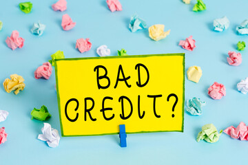 Word writing text Bad Credit Question. Business photo showcasing a bad credit score due to nonpayment of loans Colored crumpled papers empty reminder blue floor background clothespin