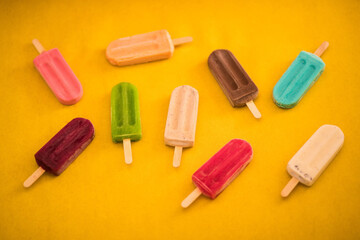 Popsicles scattered in yellow background