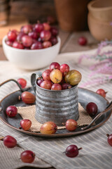 Red fresh gooseberries on wooden table