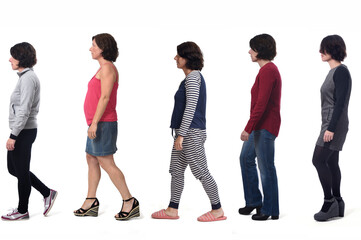 Obraz premium woman dressed in different outfits like sportswear, blue jeans, dress,skirt and pajamas walking on white background