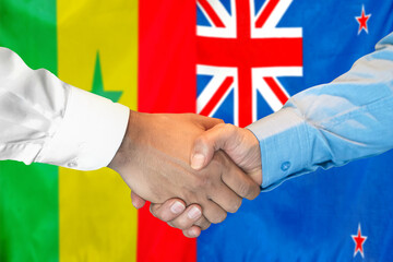 Handshake on Senegal and New Zealand flag background. Support concept.