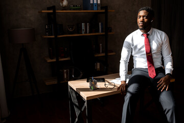 Portrait of handsome african business man with red tie and black glasses in the office