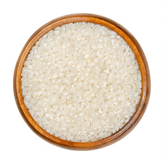 White short grain rice in wooden bowl. Seeds of the grass Oryza sativa, also known as Asian rice. Cereal grain and staple food. Used for risotto or sushi. Closeup over white isolated macro food photo.