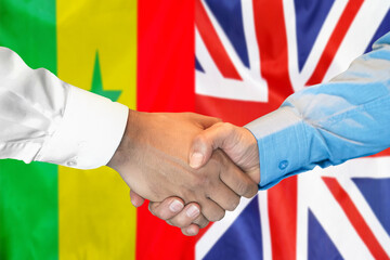 Handshake on Senegal and United Kingdom flag background. Support concept.
