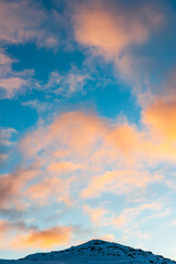 Colorful clouds above snowy mountain