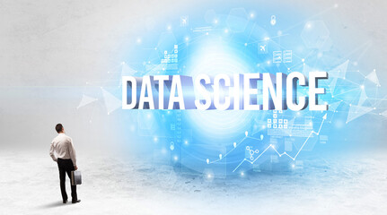 Rear view of a businessman standing in front of DATA SCIENCE inscription, modern technology concept