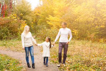 Picture of lovely family in autumn park, young parents with nice adorable daughter playing outdoors, have fun on backyard in fall, happy family enjoy autumnal nature