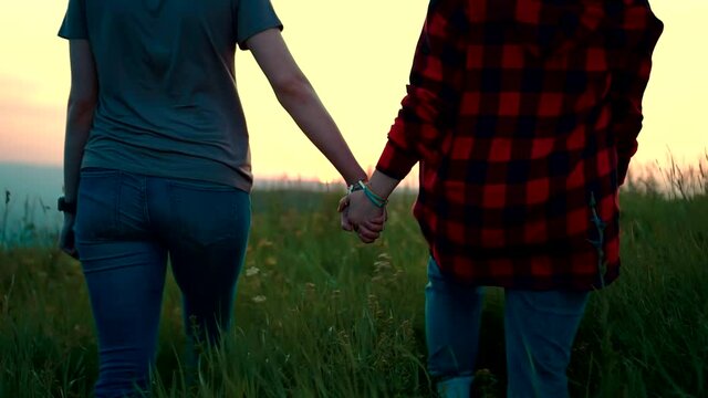 two girls holding hands at sunset lgbt