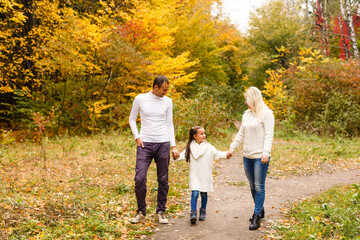 family, childhood, season and people concept - happy family in autumn park