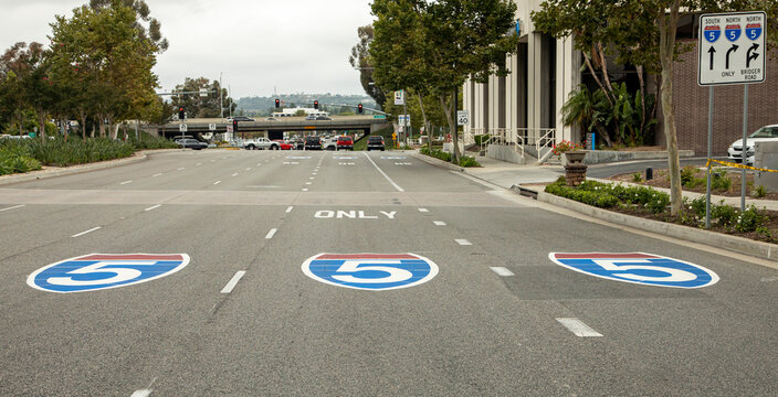 Three signs for the interstate 5 freeway painted on the pavement shot from the driver&rsquo;s perspective