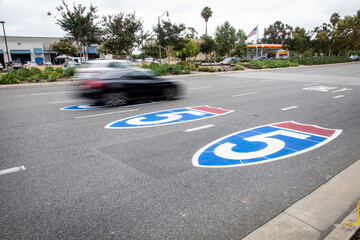 Three Road signs on asphalt for the Interstate 5 freeway with blurred traffic