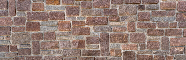 Obraz premium Panorama einer alten Mauer aus roten und grauen Sandsteinen mit breiten Fugen aus grauem Mörtel