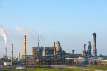 The petrochemical refinery is under blue sky and white clouds.