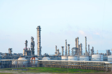 The petrochemical refinery is under blue sky and white clouds.