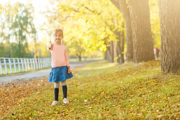 Back to school. little girl in autumn park