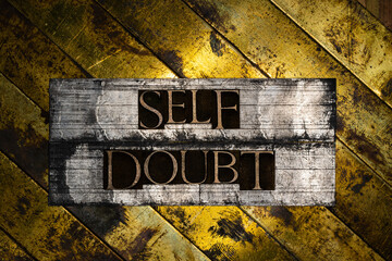 Self Doubt text formed with real authentic typeset letters on vintage textured silver grunge copper and gold background