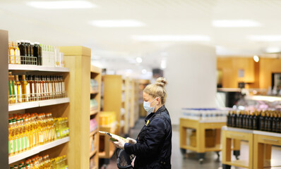 Supermarket shopping, face mask and gloves,Woman choosing a dairy products at supermarket
