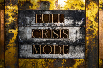 Full Crisis Mode text formed with real authentic typeset letters on vintage textured silver grunge copper and gold background