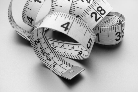 A curled tape measure. Black and white image.