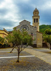 Obraz premium A view across the courtyard towards the striped church of Saint Andrea in the village of Levanto, Italy in the summertime