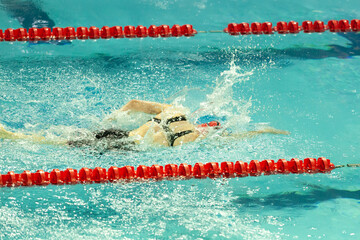 A swimmer performs the freestyle swim stroke during a swimming competition.