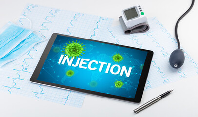 Close-up view of a tablet pc with INJECTION inscription, microbiology concept