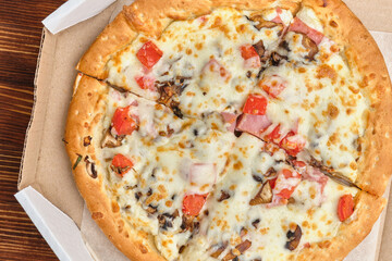 Carbonara pizza in carton packs on a wooden background