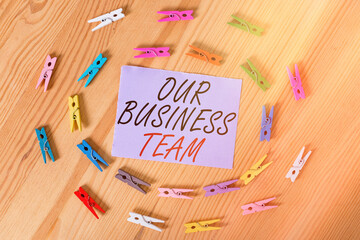 Handwriting text Our Business Team. Conceptual photo meeting and brainstorming, strategic partnership, crowdfunding, success Colored clothespin papers empty reminder wooden floor background office