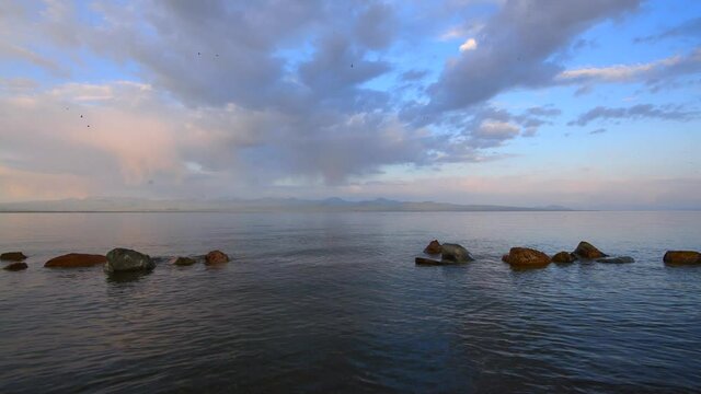 Beautiful sunrise on the lake with colorful clouds. Armenia Sevan lake