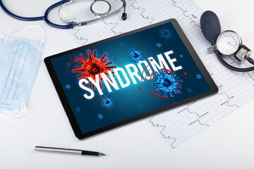 Tablet pc and doctor tools on white surface with SYNDROME inscription, pandemic concept