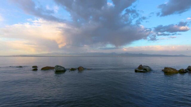 Beautiful sunrise time-lapse on the lake with colorful clouds. Armenia Sevan lake
