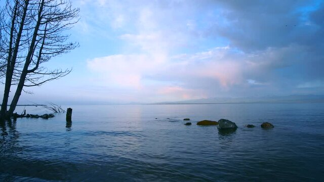 Beautiful sunrise on the lake with colorful clouds. Armenia Sevan lake
