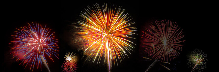 Composite panoramic photo image of multiple fireworks bursts on a black background