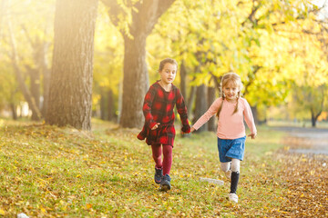 Two little girl friends schoolgirl in the park.