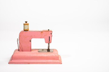 Antique children's toy sewing machine isolated on a white background with room for copy to the right