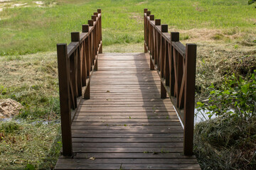 Obraz premium A small wooden bridge over a stream. Symmetrical photo.