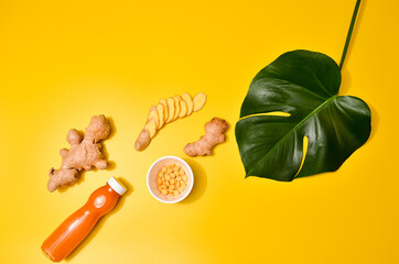 Ginger in different conditions: fresh, dry root, pills and cut plant on pastel yellow orange...