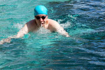 Fototapeta na wymiar The young man swims sports style