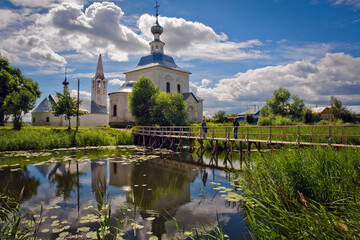 Old church, wooden bridge and reflection in the water. Suzdal. Russia.